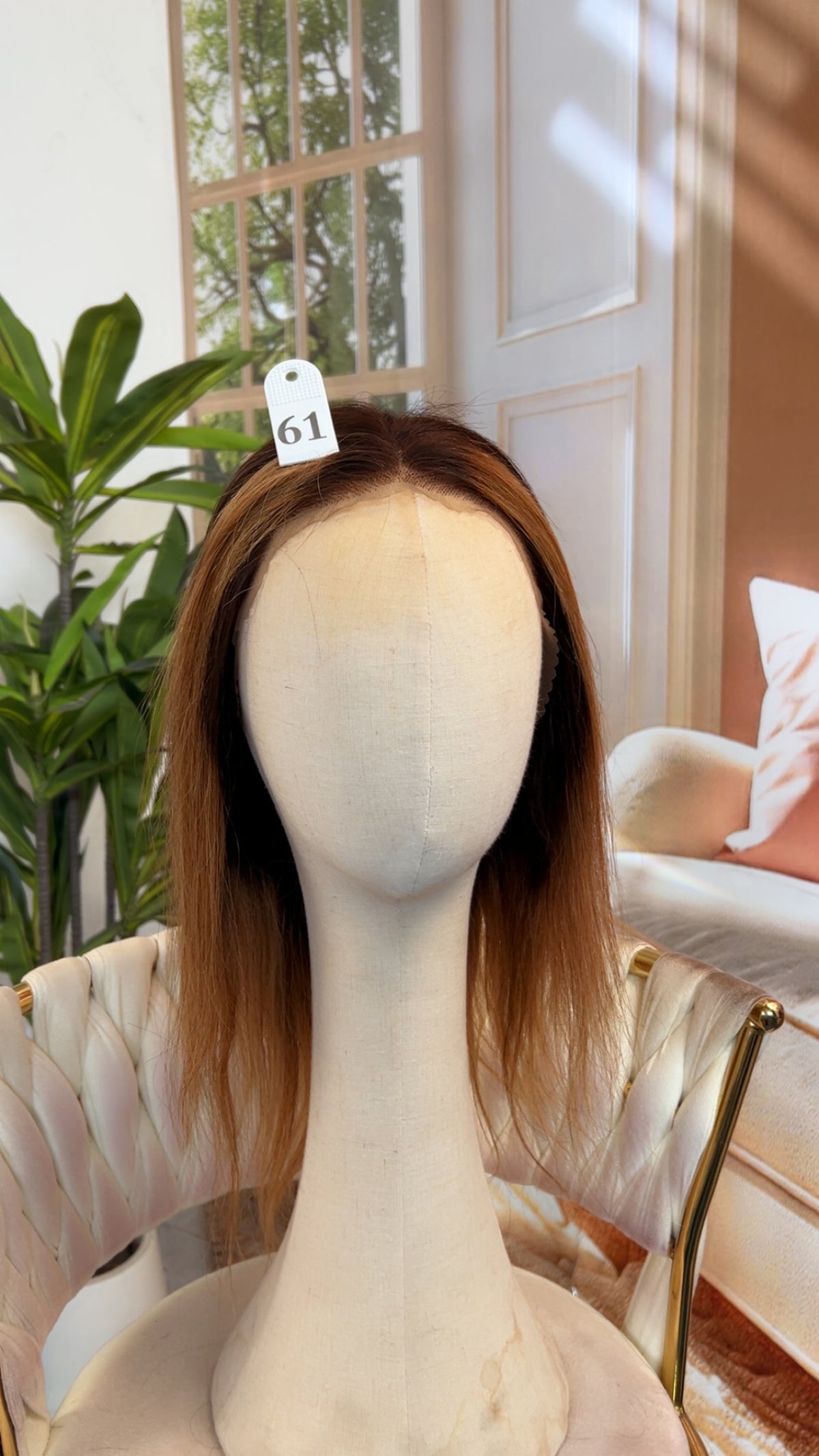 Luvme Hair outlet wig displayed on a mannequin head, showcasing curly synthetic hair style with natural hairline and volume.