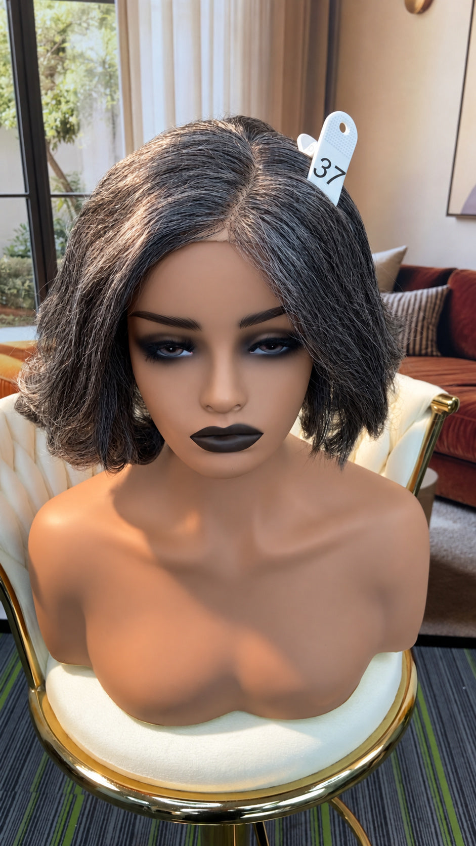 Luvme Hair outlet wig with natural black straight hair, styled with a center part, displayed on a wig stand.