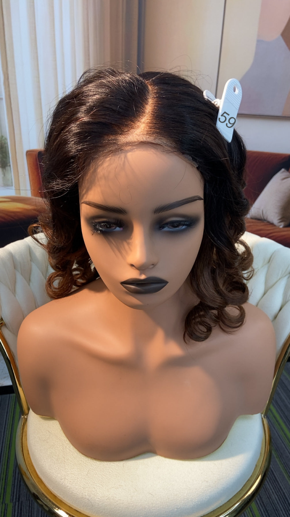 Luvme Hair live outlet wig display showing a stylish, natural-looking curly wig in a retail setting.