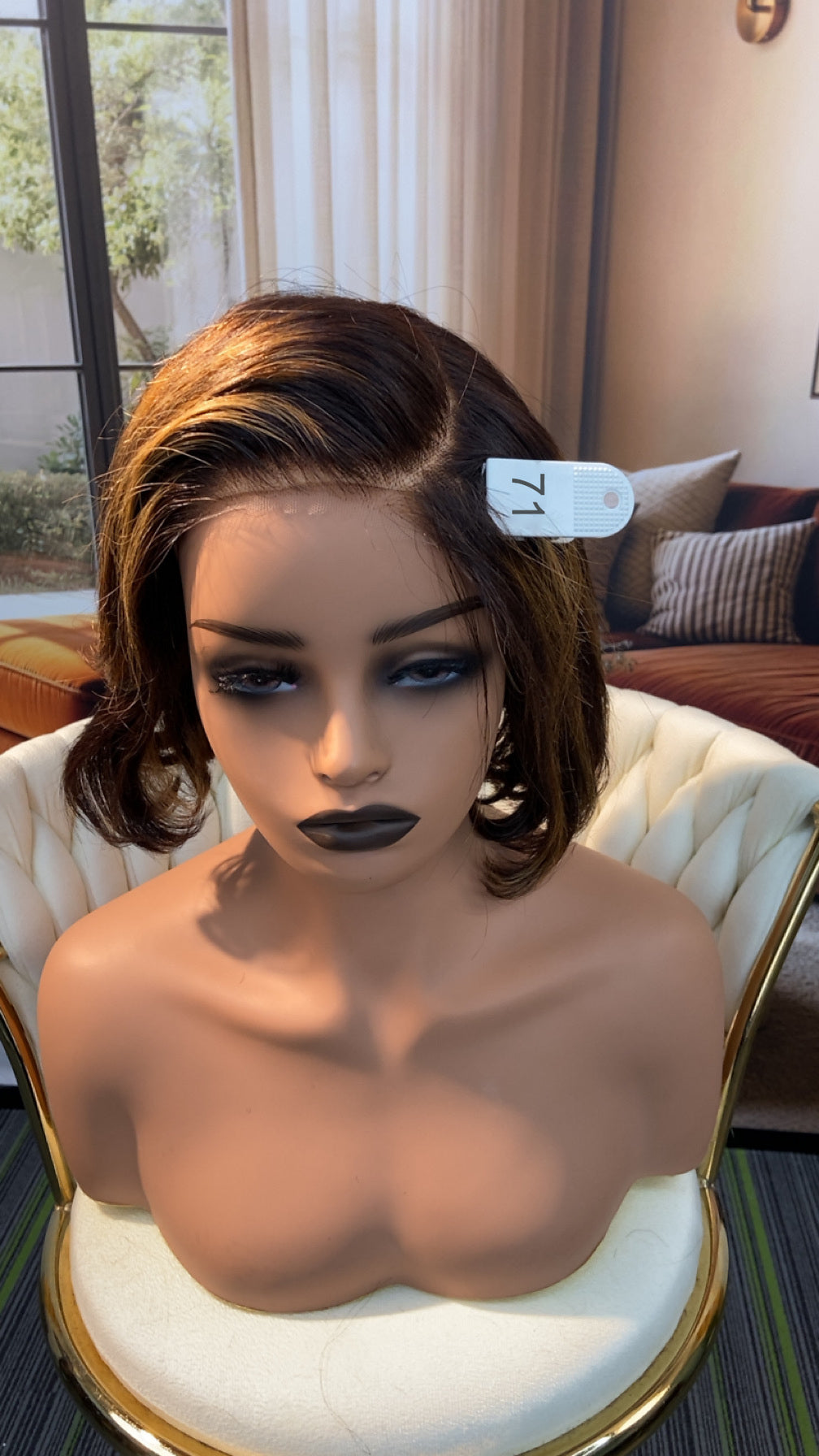 Luvme Hair outlet wig in natural black, showcasing a curly style on a mannequin head with realistic scalp and hair texture.