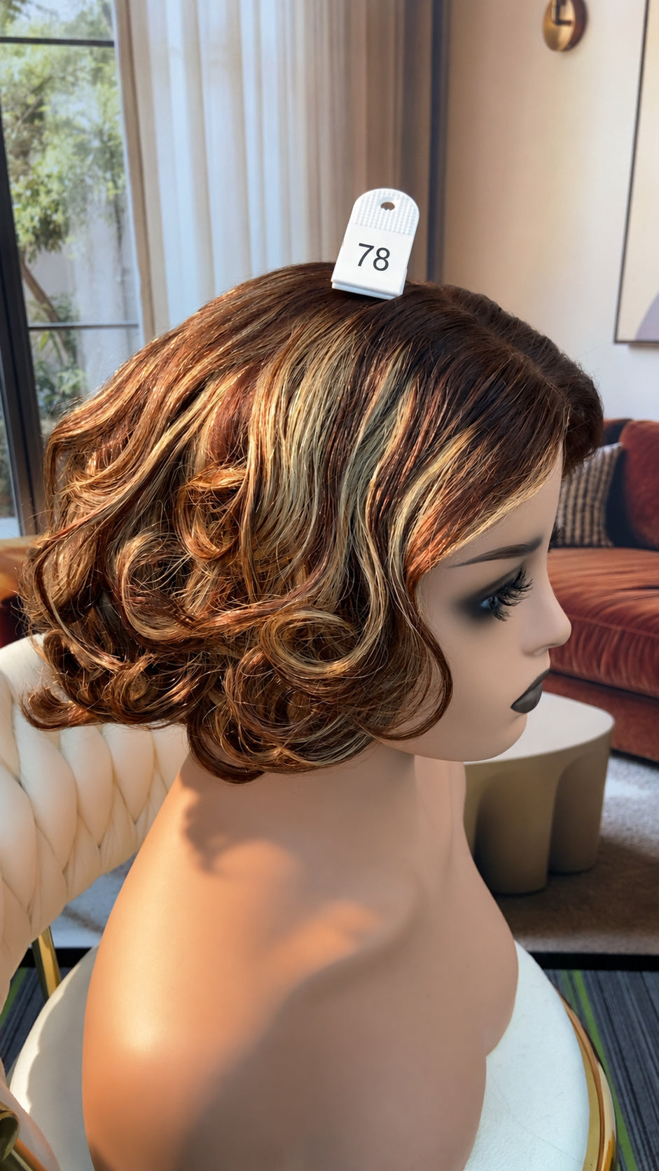 Luvme Hair live outlet wig display, showcasing a styled synthetic wig with vibrant color and natural waves, on a mannequin.