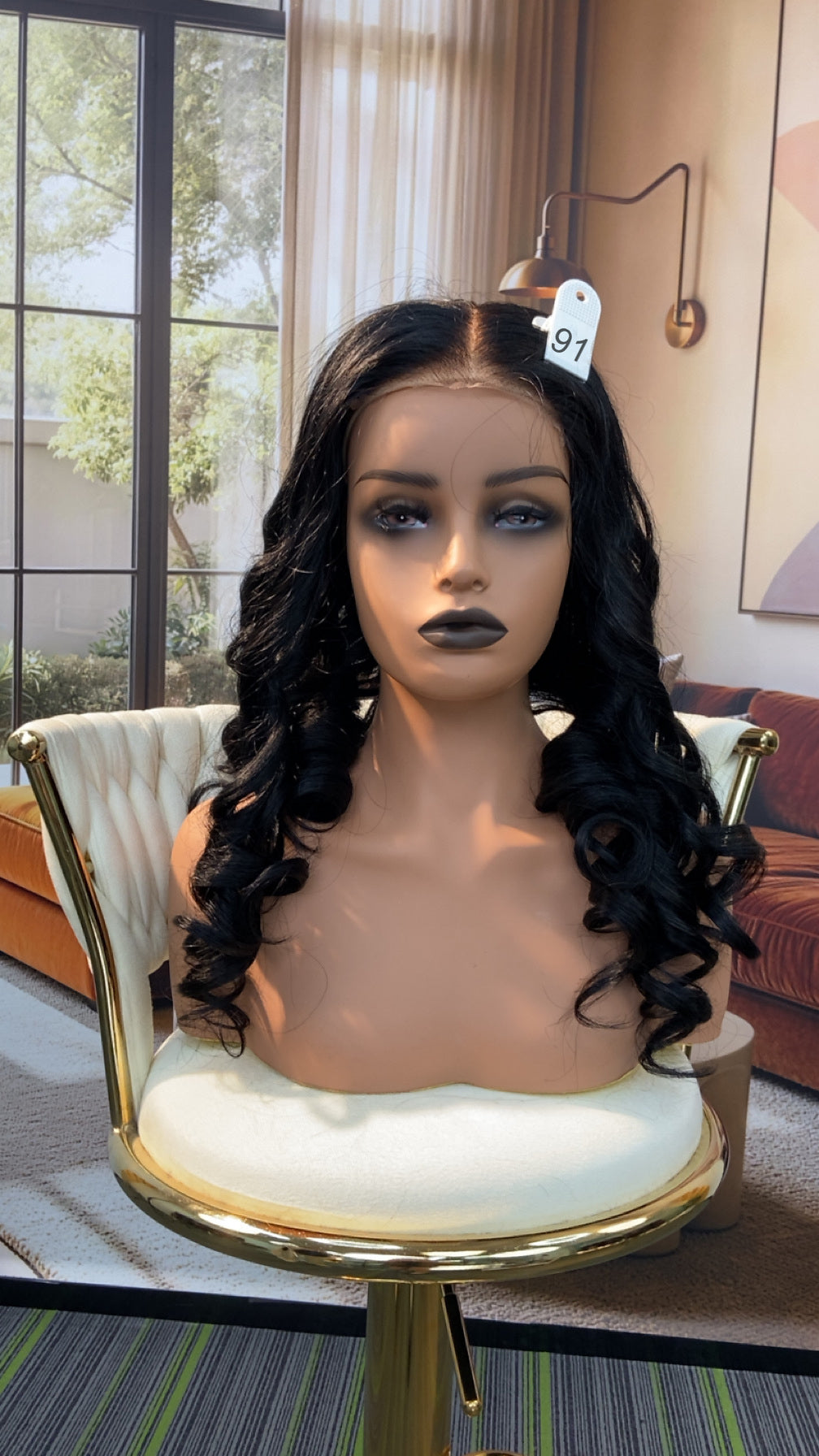 Luvme Hair live outlet wig with natural black hair, styled in loose waves, displayed on a mannequin head.