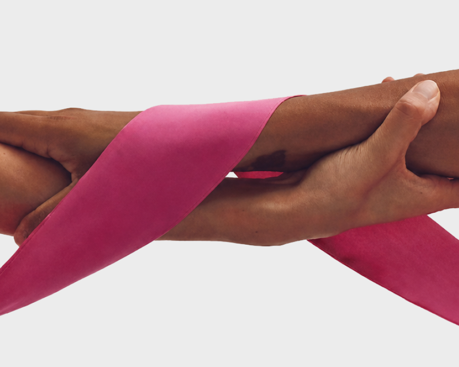 Hands joined by a pink ribbon