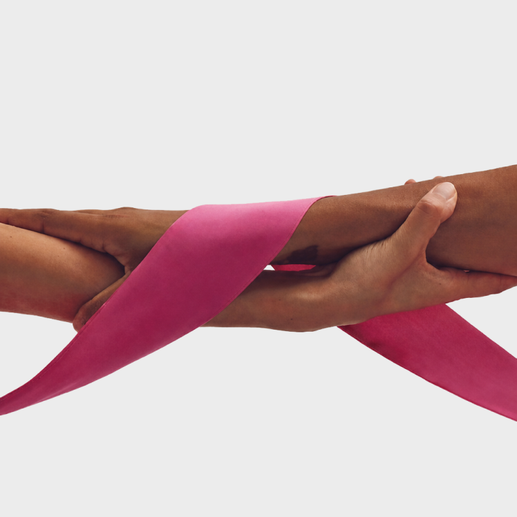 Hands joined by a pink ribbon